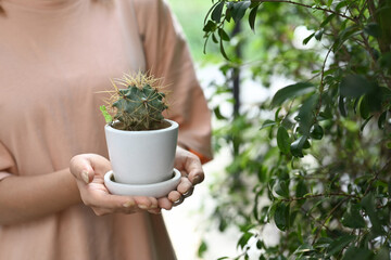 Young woman hands holding cactus pot. Environment protection, take care of plants concept.