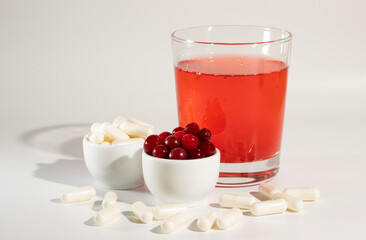 Glass of cranberry juice, cranberries, vitamins.