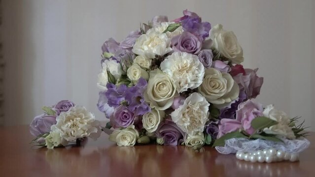 Wedding accessories: Bride's wedding bouquet with purple flowers and silver wedding eardrops. The bride's bouquet. wedding rings