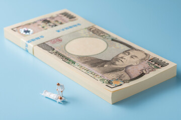 お金（お札）とミニチュアの医者