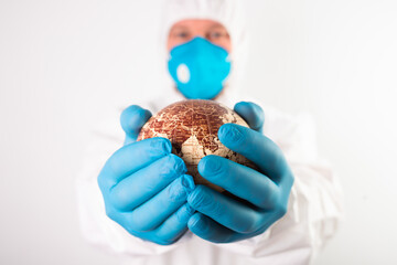 Doctor holding the planet Earth in a medical mask.