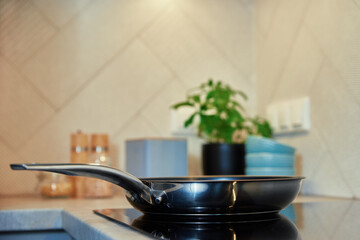 Steel frying pan in the kitchen on electric induction hob, Modern kitchen appliance