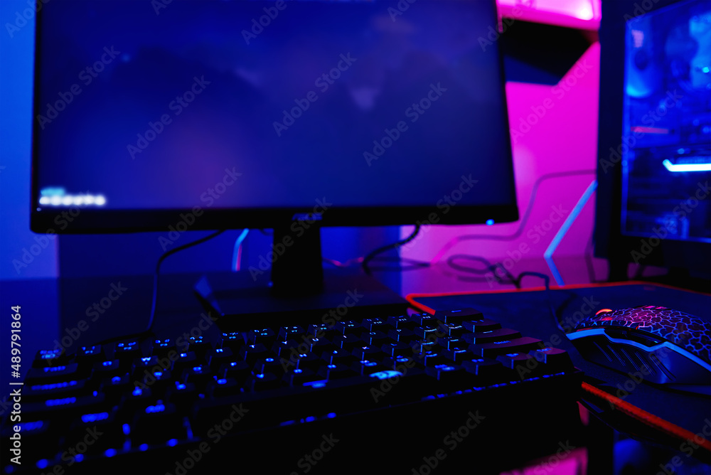 Poster pc with rgb keyboard for gaming computer video games with neon colored background, dark room with ga