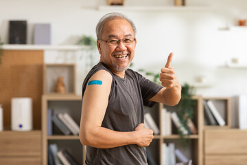 Happy Asian Elderly man received anti virus vaccine cheerful thumbs up with bandage,Senior handsome...