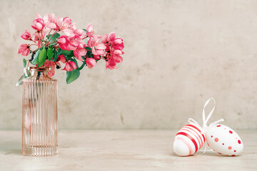 Happy Easter. Easte egg on spring festive blooming with pink white flowers fruit tree branches in small vase against tender pastel background. Fresh floral background with copy space