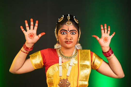 Young indian Bharatnatyam dancer performing anger posture or roudra rasa dance on stage - concept of Professional traditional indian dancer