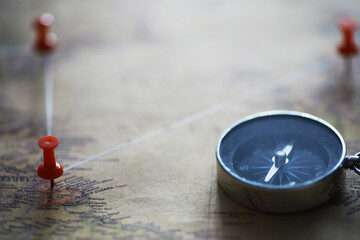 Travel concept. Map and needle with a marked place. Compass point on the map and routes.