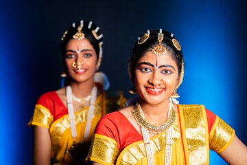 Smiling Bharatnatyam dancers on stage performance - concept of Indian classcal dancers, entertainment and traditional culture.