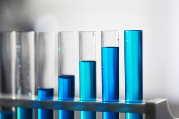 Test tube with blue liquid on the laboratory table. Examination of liquid under a microscope.