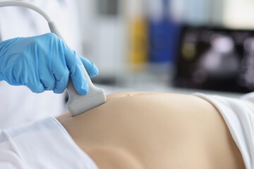 Gynecologist doing ultrasound scan on belly, doctor examining womans baby