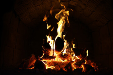 Background of the flame in the oven. Tongues of fire in a brick fireplace. Fire texture.