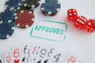 Stamp approved standing near playing cards and chips in casino with dice