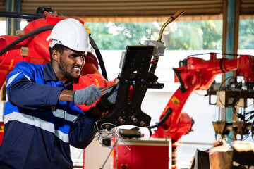 Engineer worker wearing safety goggles repair or maintenance robotics machine to weld components of nut and steel. Metal lathe industrial manufacturing factory indoors. Dreaming future projects