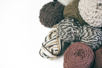 Panoramic view of composition with knitting accessories: balls of wool yarn, set of knitting needles, hooks, and other knit tools on white background. Long banner, top view, copy space, flat lay.