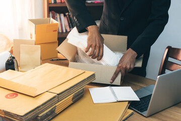 Small business owner packing in the card box at workplace. Cropped shot of man preparing a parcel for delivery at online selling business office. Ecommerce drop shipping shipment service concept.