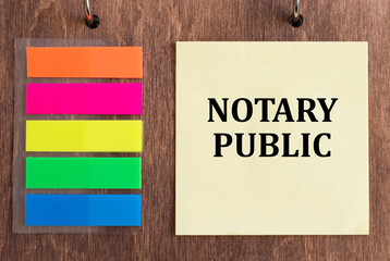 white card with text Notary Public on a wooden background next to colored stickers