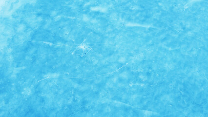 Aerial view of the beautiful blue texture of ice on the surface of the lake in winter