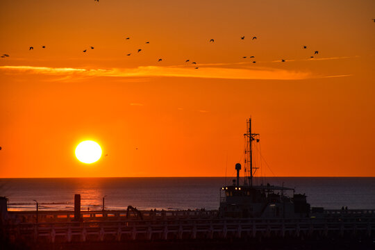 Boat at river Yser estuary, North sea at sunset on a crisp winter day, 27 February 2022.