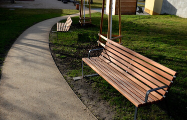 rows of reddish wood benches on their paneling under the benches is a rectangle of concrete...