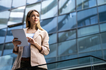 Portrait of successful woman using digital tablet in urban background. Business people concept