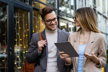 Portrait of two smiling business people walking and talking together in urban background