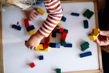 Father and son playing with toy blocks at home