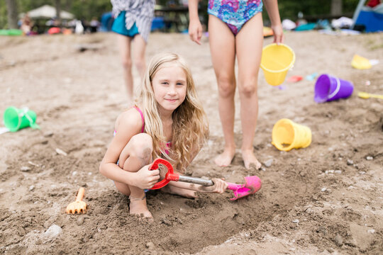 Girls with beach toys playing in sand at beach
