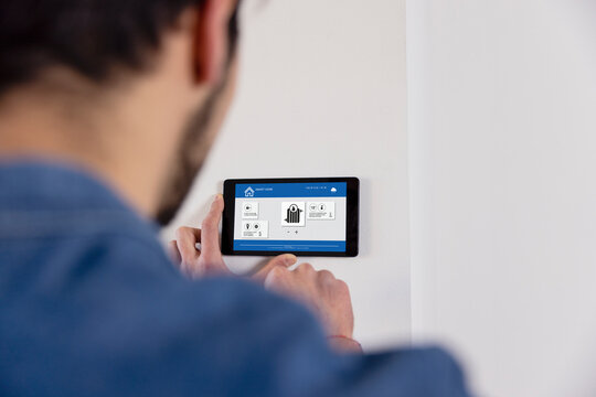 Man using IOT home app through tablet PC at new home