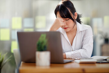 Tired frustrated asian businesswoman feeling stressed, upset executives sitting near laptop,...