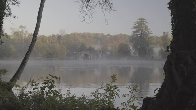 Stone grotto at Majolan Park lake in Blanquefort France, Dolly left reveal shot