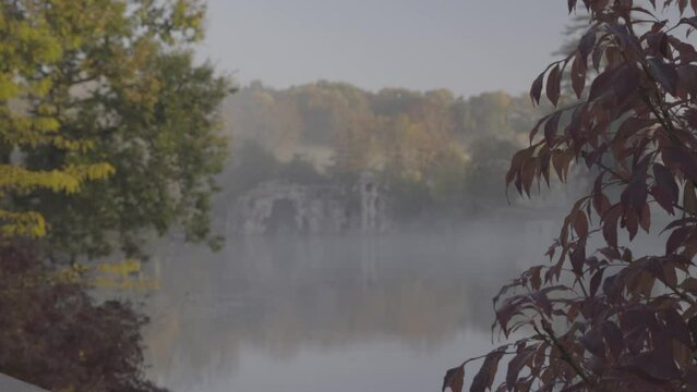 Man made Grotto at Majolan Park lake in Blanquefort France with trees in foreground, Rack focus shot