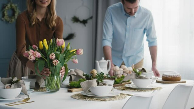Caucasian couple preparing  table for easter dinner. Shot with RED helium camera in 8K.