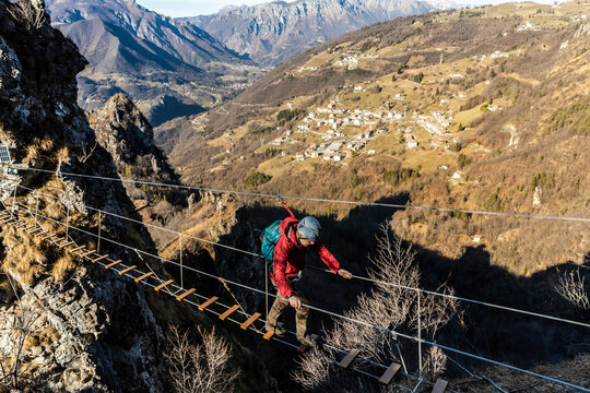 Adventurous man crossing Tibetan bridge, Orobie alps, Bergamo, Italy