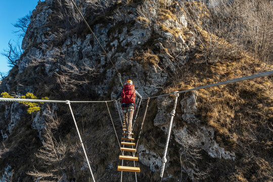 Hiker crossing suspension bridge at Orobie alps, Bergamo, Italy