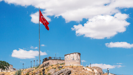 Castle in the city of potters Avanis with the Turkish flag against the blue sky, Turkey.