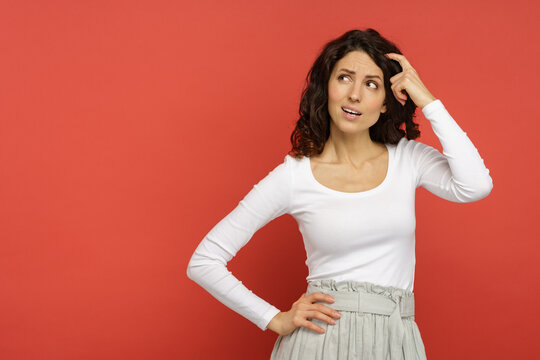 Thoughtful italian female minded thinking, creating solution planning idea looking up with hand on head and hair. Young hispanic woman pensive thinking isolated on red background on copy space.
