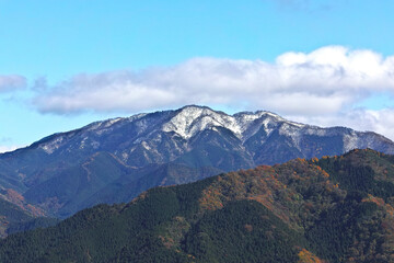 秋の終わりと山頂に積もる雪