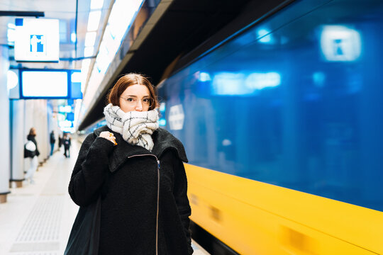 Young Woman Wrapped In Scarf At Subway Station