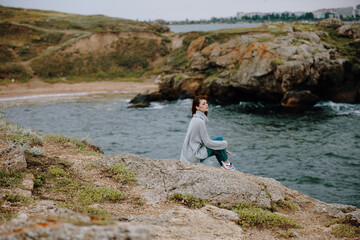 portrait of a woman seated on the coast sweater landscape female relaxing