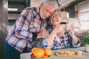 Happy senior man embracing senior woman in camper van