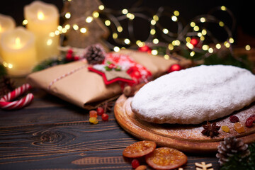 Obraz na płótnie Canvas Traditional Christmas stollen cake and New Year decorations on wooden background