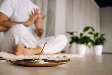 Close-up of a man in white sportswear doing yoga in a fitness room with a balgovon. the concept of...