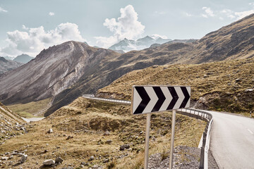 Sign board by road and mountains, Italy