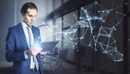 Attractive young european businessman using tablet with abstract polygonal network mesh hologram on blurry office interior background. Metaverse and AI concept.