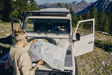 Woman analyzing map on off-road vehicle at Col d'Izoard, Arvieux, France