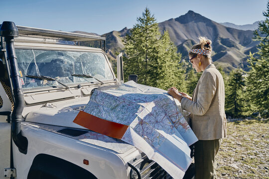 Tourist examining map on off-road vehicle at Col d'Izoard, Arvieux, France