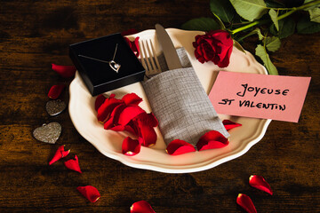  assiette rempli de pétale de rose rouge avec écrit en Français joyeuse saint valentin et un...