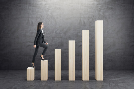 Businesswoman walking on abstract business chart bars on concrete wall background. Financial, career growth and success concept.
