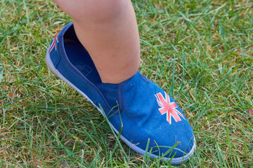 baby in big shoes,little girl in the summer on the dora in adult shoes