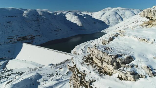 Faraya-Chabrouh Dam full of water under white snowy landscape. Winter in Lebanon